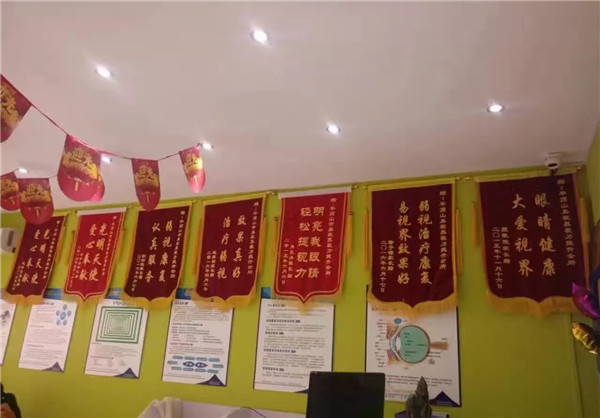 易視界效果奇特家長贈(zèng)送的錦旗掛滿墻